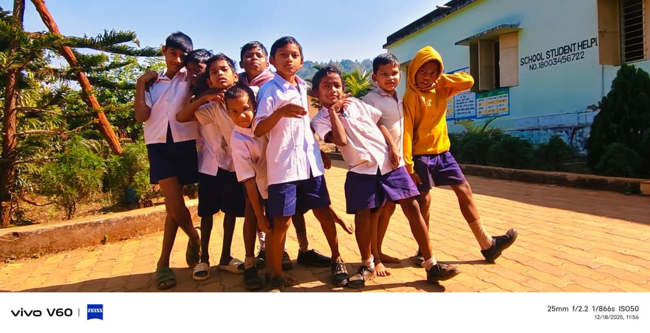 Nine boys in school uniform crowded into a pose on the paving outside a school building